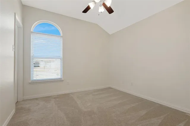 an empty room with a window and a ceiling fan