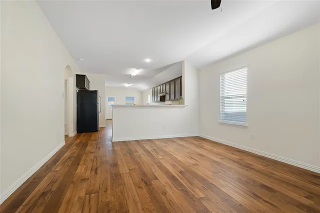a view of a big room with wooden floor and a kitchen