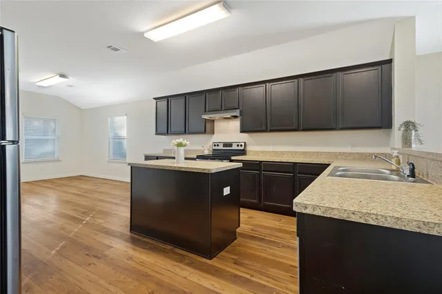 a kitchen with a sink cabinets and wooden floor