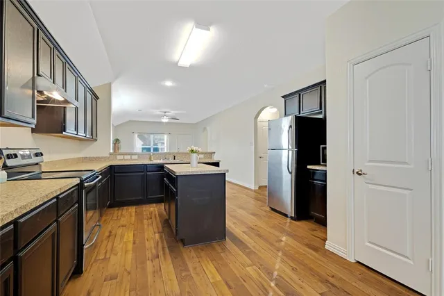 a kitchen with a refrigerator and a stove top oven