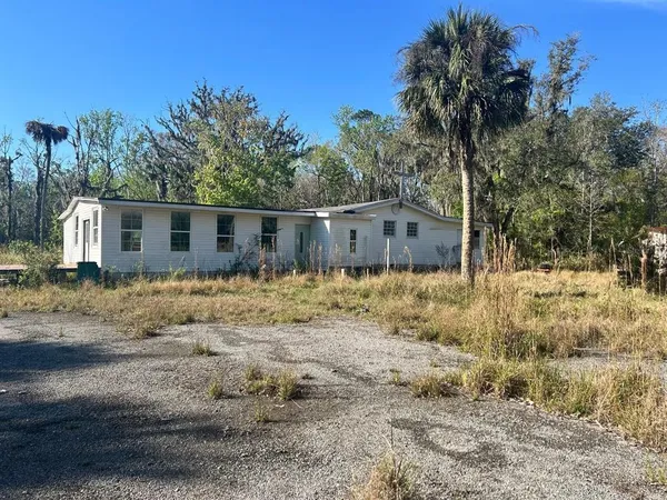 a view of a house with a yard covered in snow