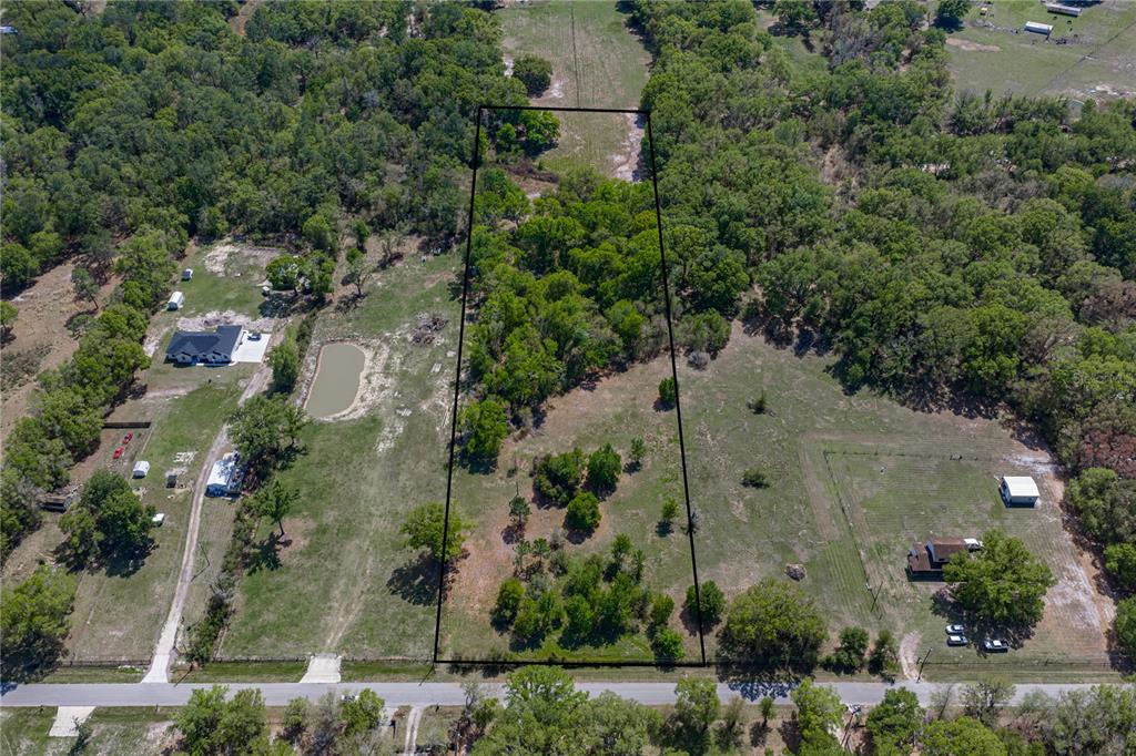 an aerial view of a residential houses with outdoor space and street view