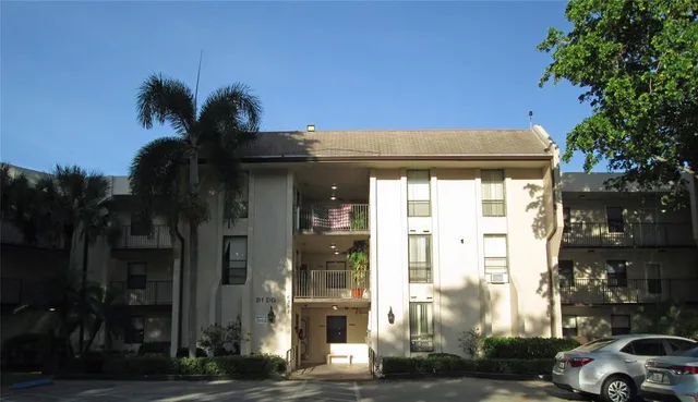 a view of a building and car parked on the roadside