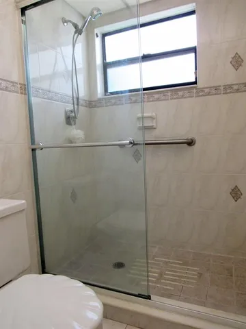 a white toilet sitting next to a shower