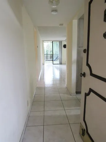 a view of hallway with a window and chandelier