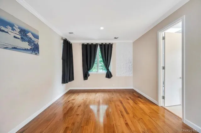 a view of a big room with wooden floor and windows