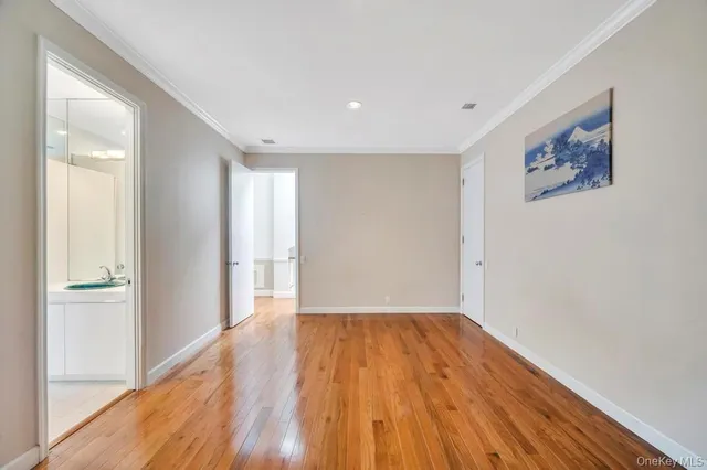 a bedroom with a large bed and wooden floor
