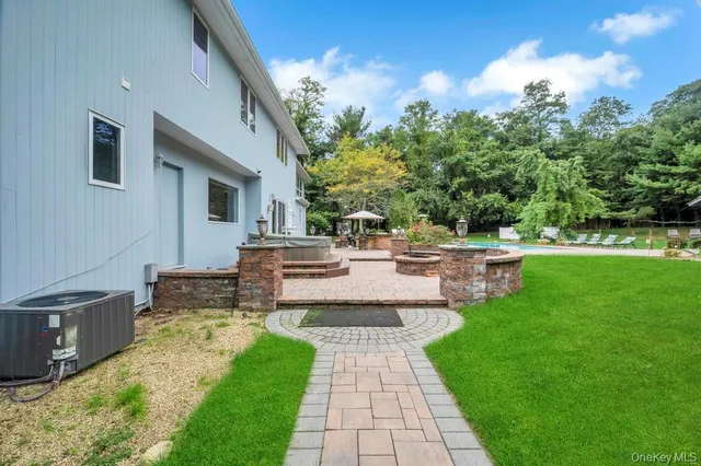 a view of a tables and chairs under an umbrella in backyard