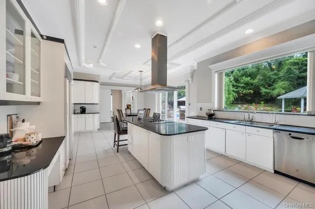 a kitchen with stainless steel appliances kitchen island granite countertop a refrigerator and white cabinets
