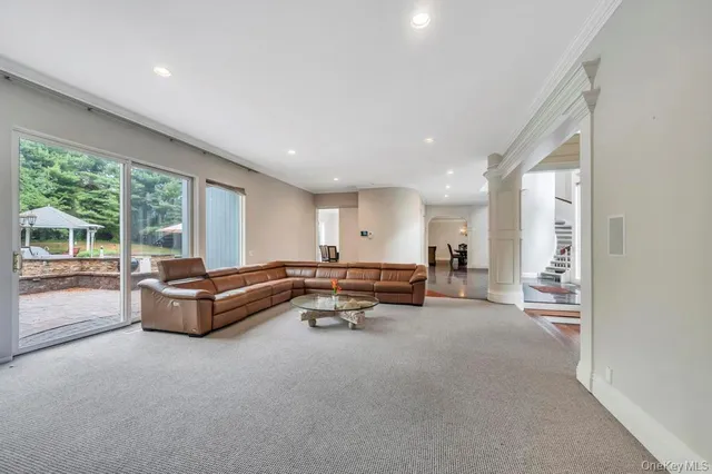 a dining room with wooden floor and a floor to ceiling window