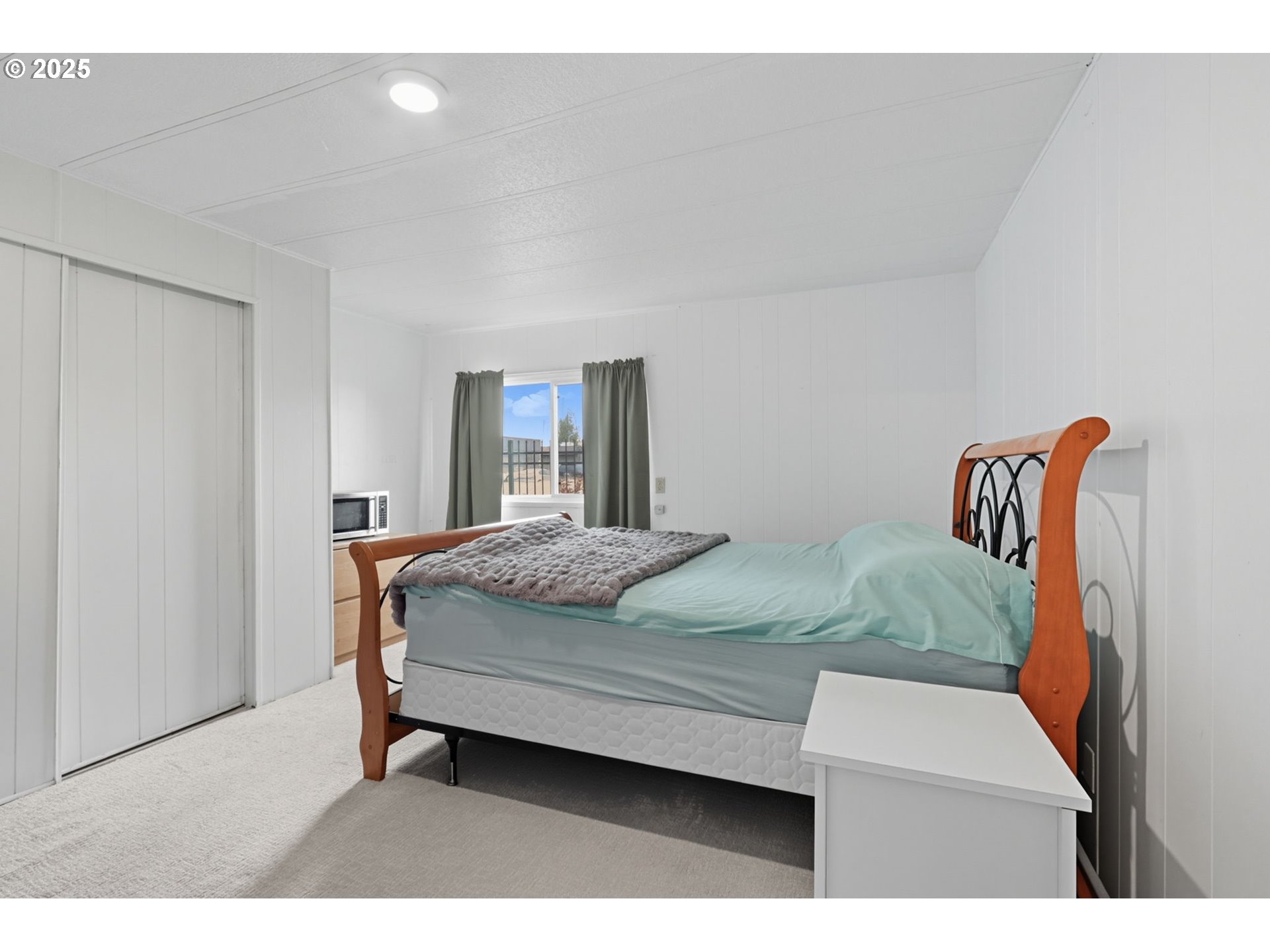 300 Southwest 7th Avenue, Unit 95 Battle Ground, WA 98604 - Photo 12 of 27 a bedroom with a bed and a painting on the wall