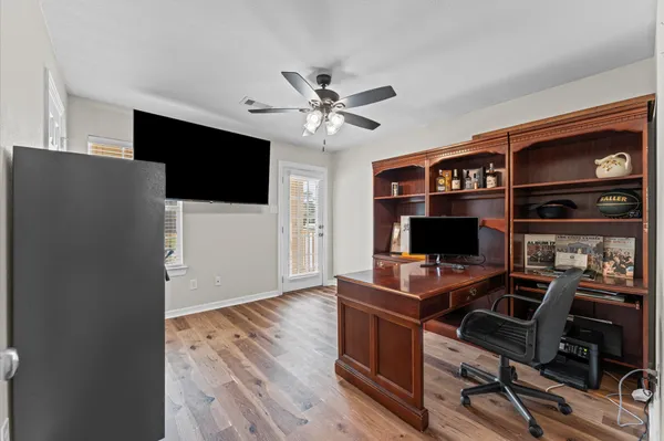 a view of a workspace with furniture and wooden floor