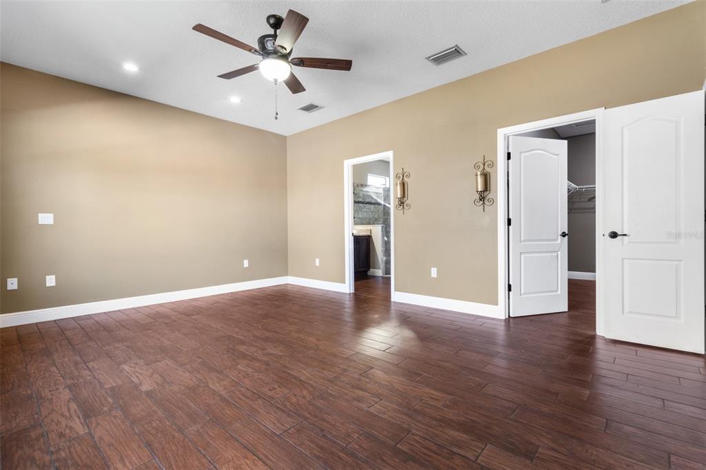 765 Sloans Ridge Road Groveland, FL 34736 - Photo 26 of 62 a view of an empty room with wooden floor and a ceiling fan