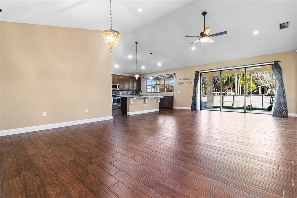 765 Sloans Ridge Road Groveland, FL 34736 - Photo 7 of 62 a view of an empty room with wooden floor and windows