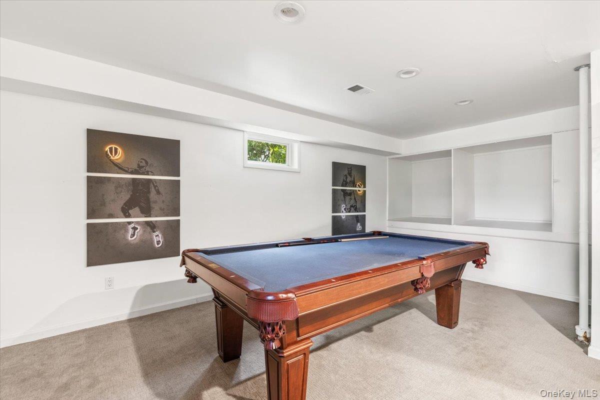 37 Talcott Road Rye Brook, NY 10573 - Photo 18 of 25 Recreation space featuring recessed lighting, built-in shelving, carpet flooring, and sliders to lower patio and back yard