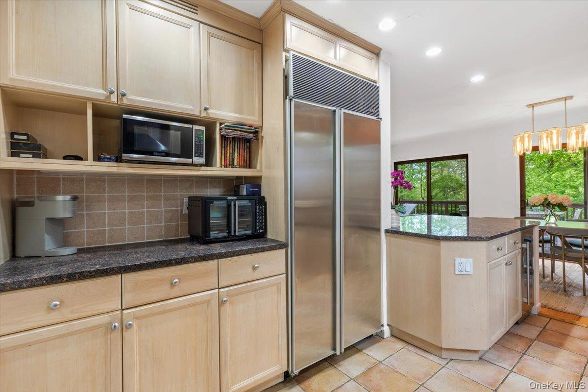 37 Talcott Road Rye Brook, NY 10573 - Photo 7 of 25 Kitchen featuring light wood cabinetry, dark granite countertops, stainless steel appliances, tile flooring, and a kitchen island with seating
