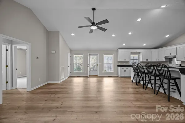 a view of a kitchen with furniture and wooden floor