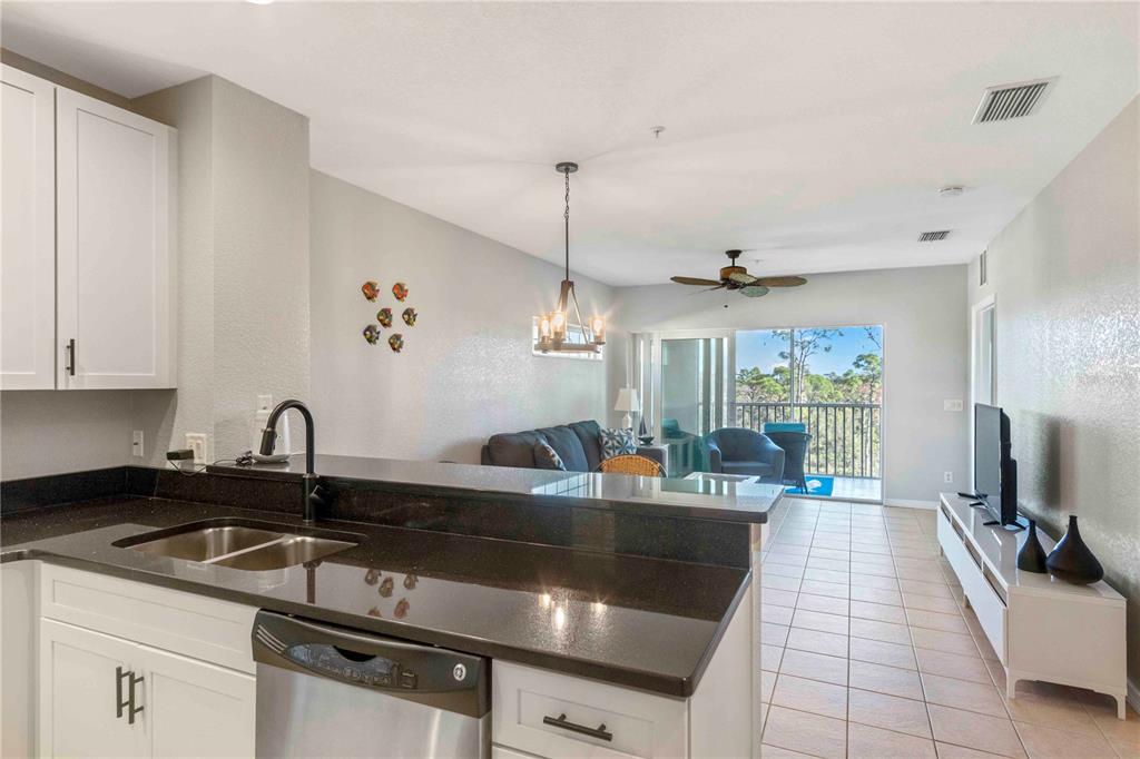 8409 Placida Road, Unit 405 Placida, FL 33946 - Photo 13 of 77 a kitchen with granite countertop a sink a counter top space appliances and cabinets