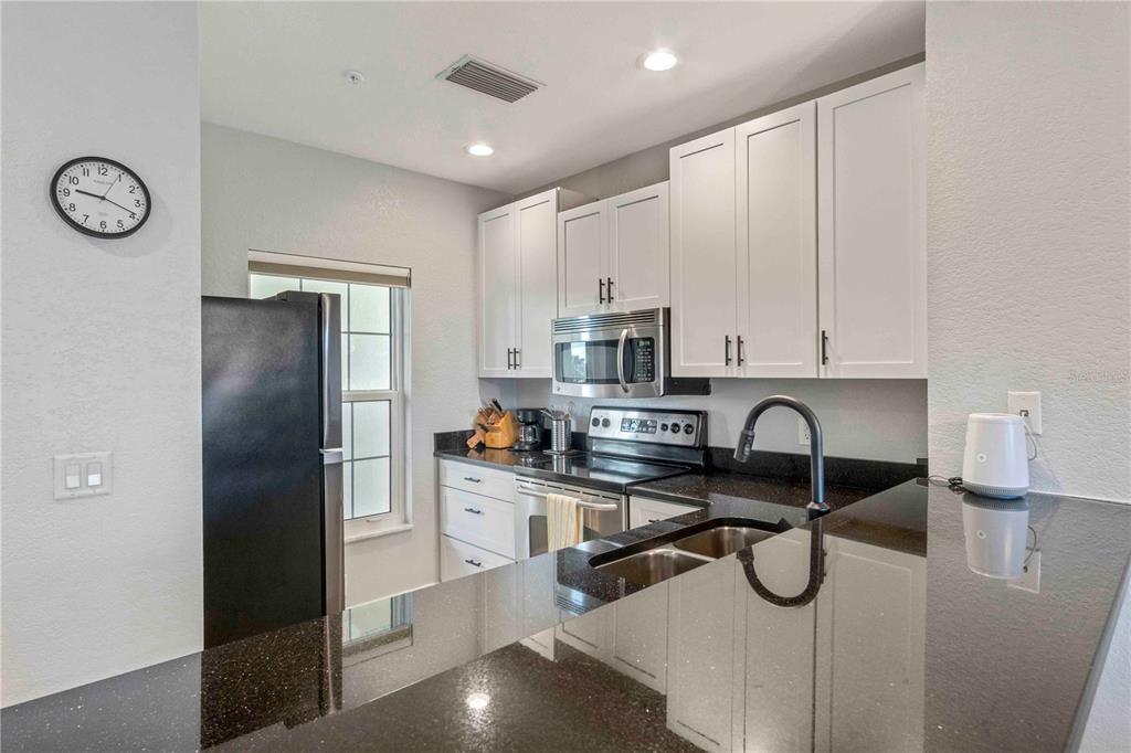 8409 Placida Road, Unit 405 Placida, FL 33946 - Photo 20 of 77 a kitchen with stainless steel appliances a refrigerator a sink a stove and white cabinets