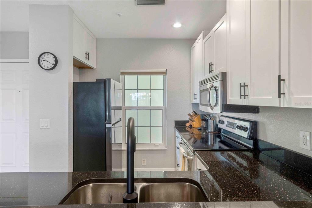 8409 Placida Road, Unit 405 Placida, FL 33946 - Photo 24 of 77 a kitchen with stainless steel appliances granite countertop a sink and a refrigerator