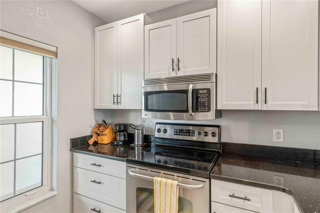 8409 Placida Road, Unit 405 Placida, FL 33946 - Photo 30 of 77 a kitchen with white cabinets and appliances