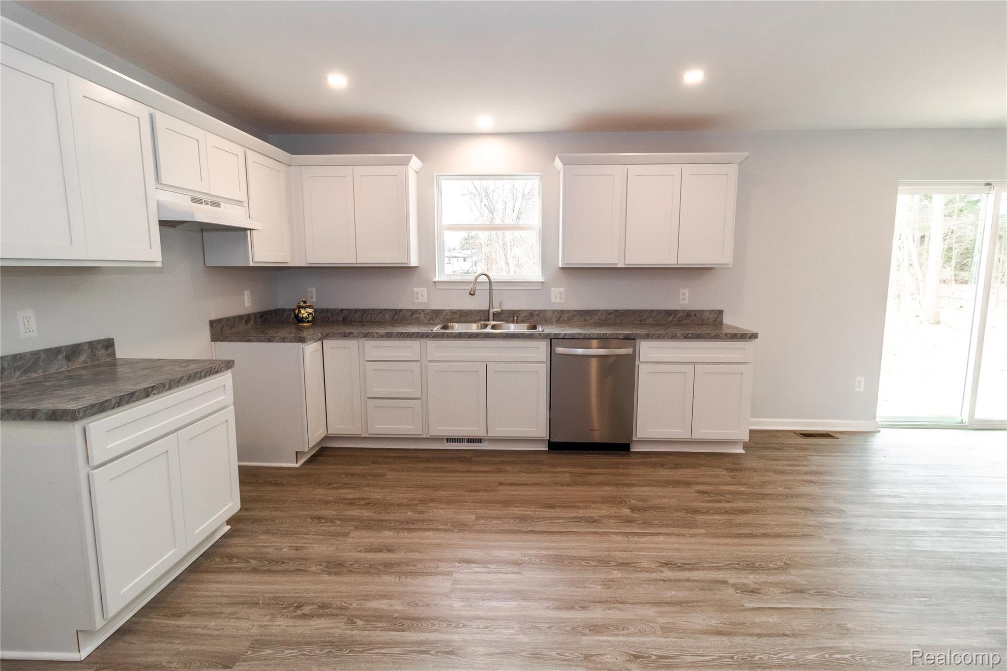 5155 Coldwater Road Lapeer, MI 48446 - Photo 6 of 24 Kitchen with dark countertops, white cabinets, stainless steel dishwasher, dark wood-style flooring, and recessed lighting