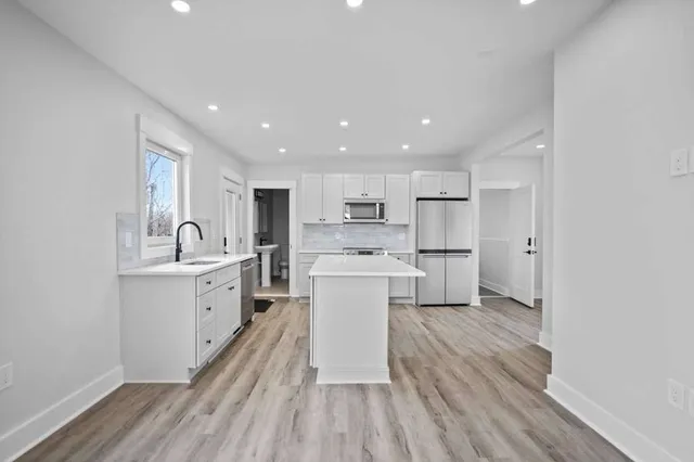 a open kitchen with white cabinets and stainless steel appliances