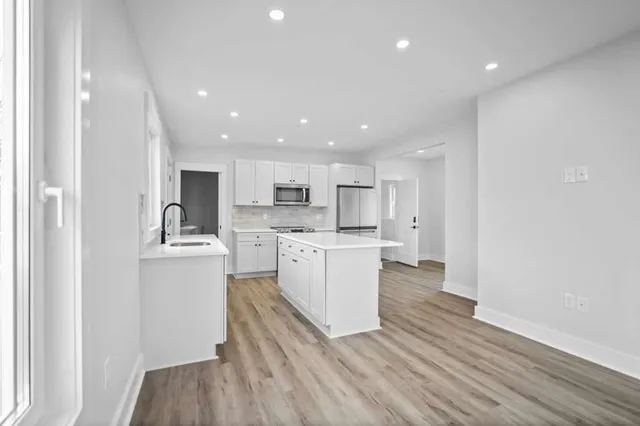 a kitchen with white cabinets and stainless steel appliances