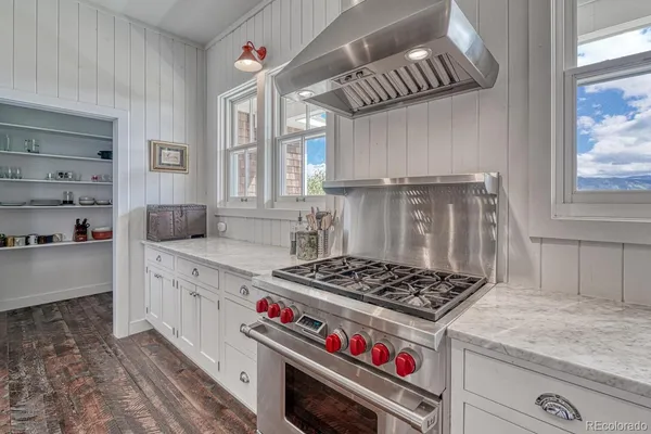 a kitchen with a stove and a wooden cabinets