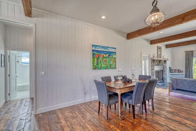 a dining room with furniture wooden floor a rug and a painting
