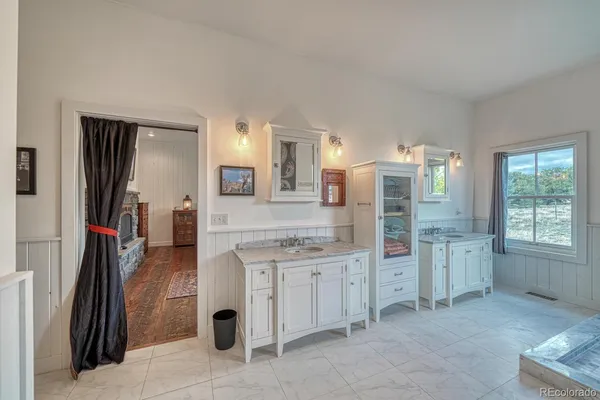 a large bathroom with a granite countertop sink a large mirror and a bathtub
