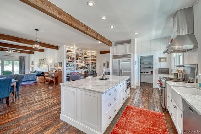 a large kitchen with stainless steel appliances granite countertop a lot of counter space and wooden floors