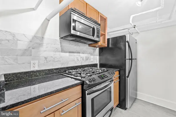 a kitchen with granite countertop a stove and a microwave