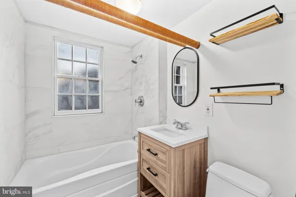 a bathroom with a granite countertop tub sink and mirror