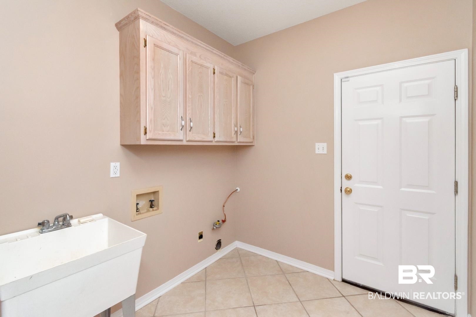 6117 Lennox Place Mobile, AL 36693 - Photo 25 of 39 Clothes washing area with cabinet space, a sink, hookup for a washing machine, baseboards, and light tile patterned floors