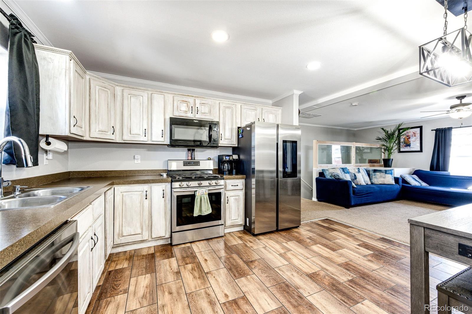 570 4th Street Bennett, CO 80102 - Photo 12 of 36 a kitchen with stainless steel appliances a refrigerator sink and stove