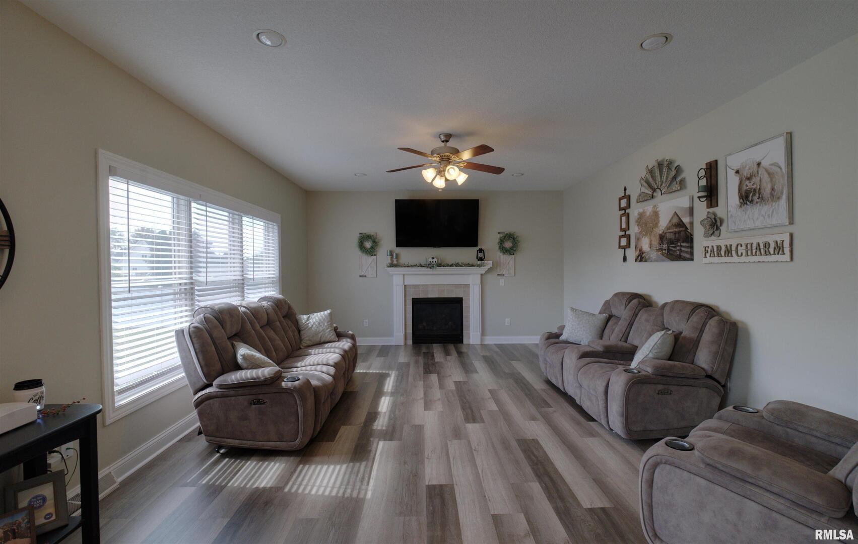 1917 11th Street Camanche, IA 52730 - Photo 11 of 40 a living room with furniture a fireplace and a flat screen tv