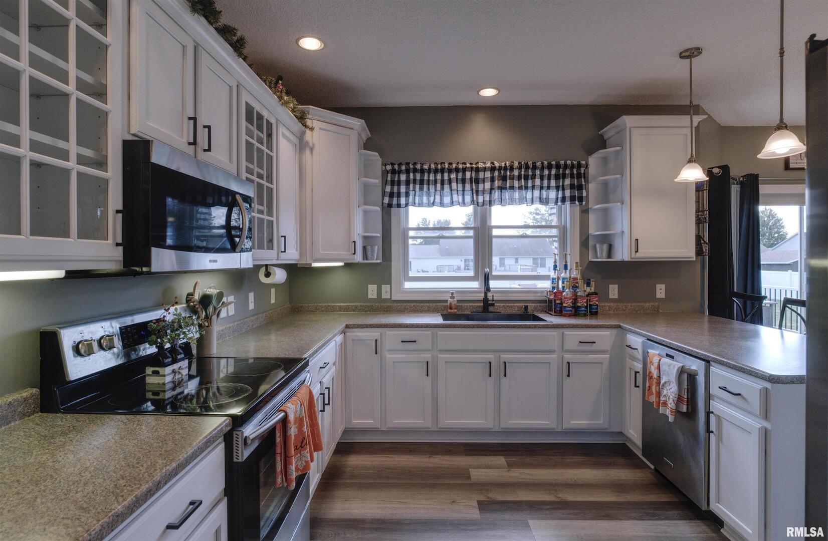1917 11th Street Camanche, IA 52730 - Photo 7 of 40 a kitchen with stainless steel appliances granite countertop a sink a stove and a wooden cabinets