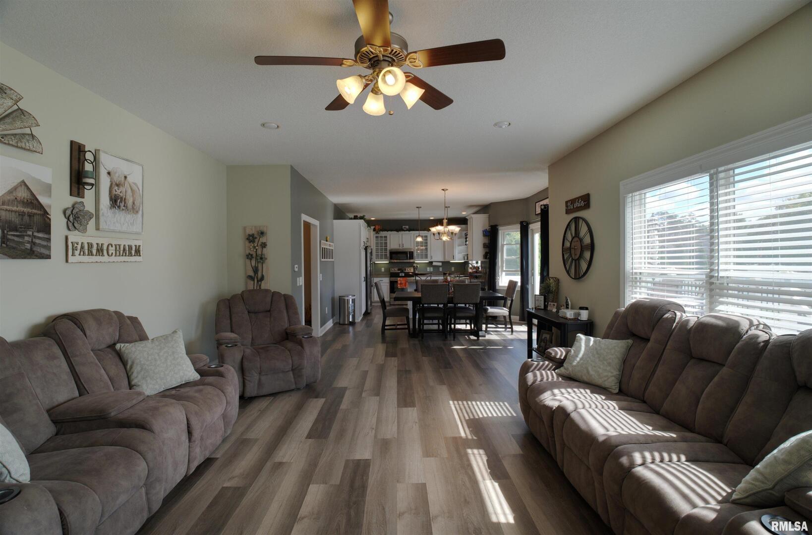 1917 11th Street Camanche, IA 52730 - Photo 10 of 40 a living room with furniture a ceiling fan and a large window