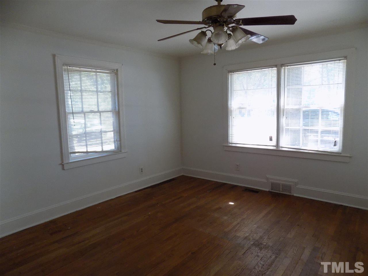1114 Kent Road Raleigh, NC 27606 - Photo 8 of 10 a view of an empty room with wooden floor and a window
