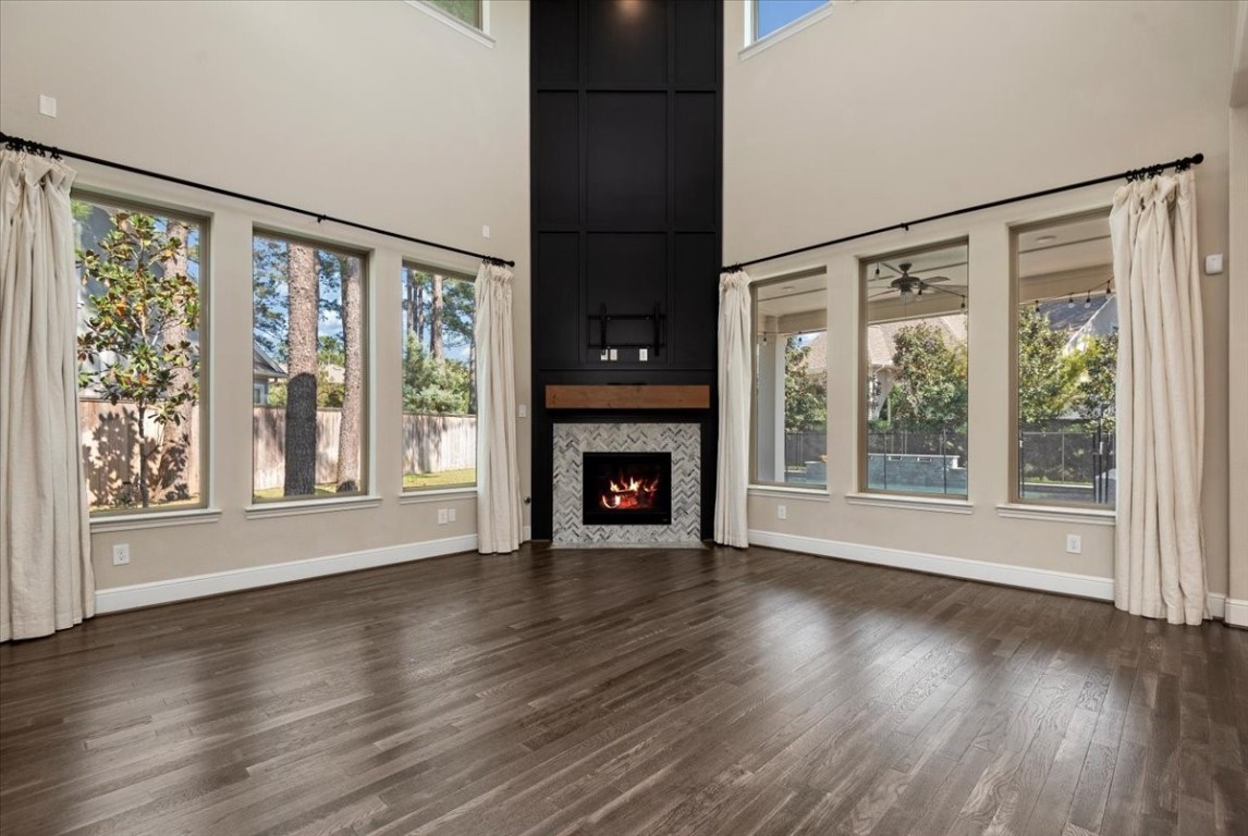 155 Rockwell Park Spring, TX 77389 - Photo 14 of 50 This stunning living space features soaring ceilings, expansive windows that flood the room with natural light, and a sleek fireplace, creating a perfect blend of elegance and warmth for any homebuyer.