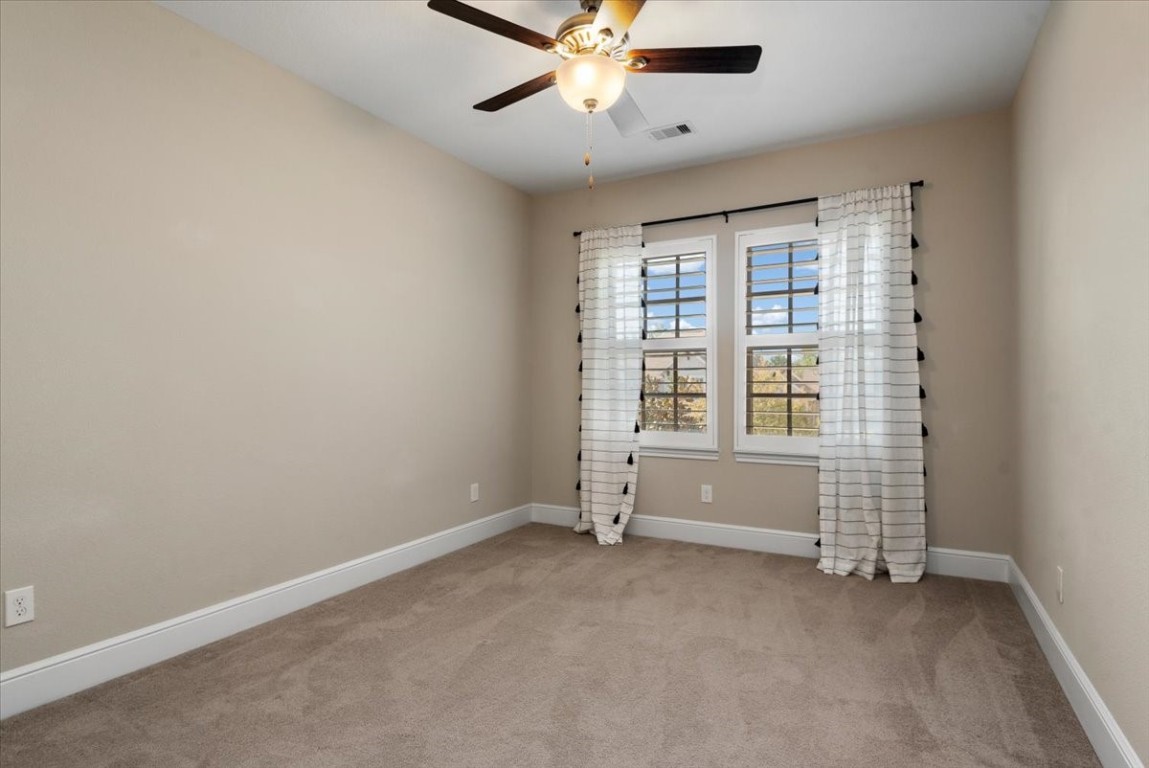 155 Rockwell Park Spring, TX 77389 - Photo 32 of 50 Experience tranquility in this inviting upstairs bedroom, featuring soft carpeting, elegant window treatments, and a stylish ceiling fan for ultimate comfort.
