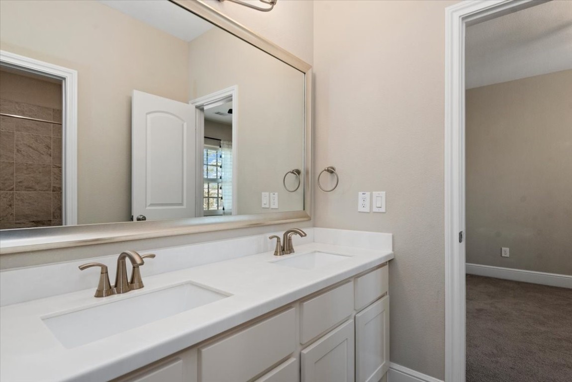 155 Rockwell Park Spring, TX 77389 - Photo 33 of 50 This elegant shared bathroom, nestled between the upstairs bedrooms, features a sleek dual vanity and modern fixtures, offering both style and convenience for family living.