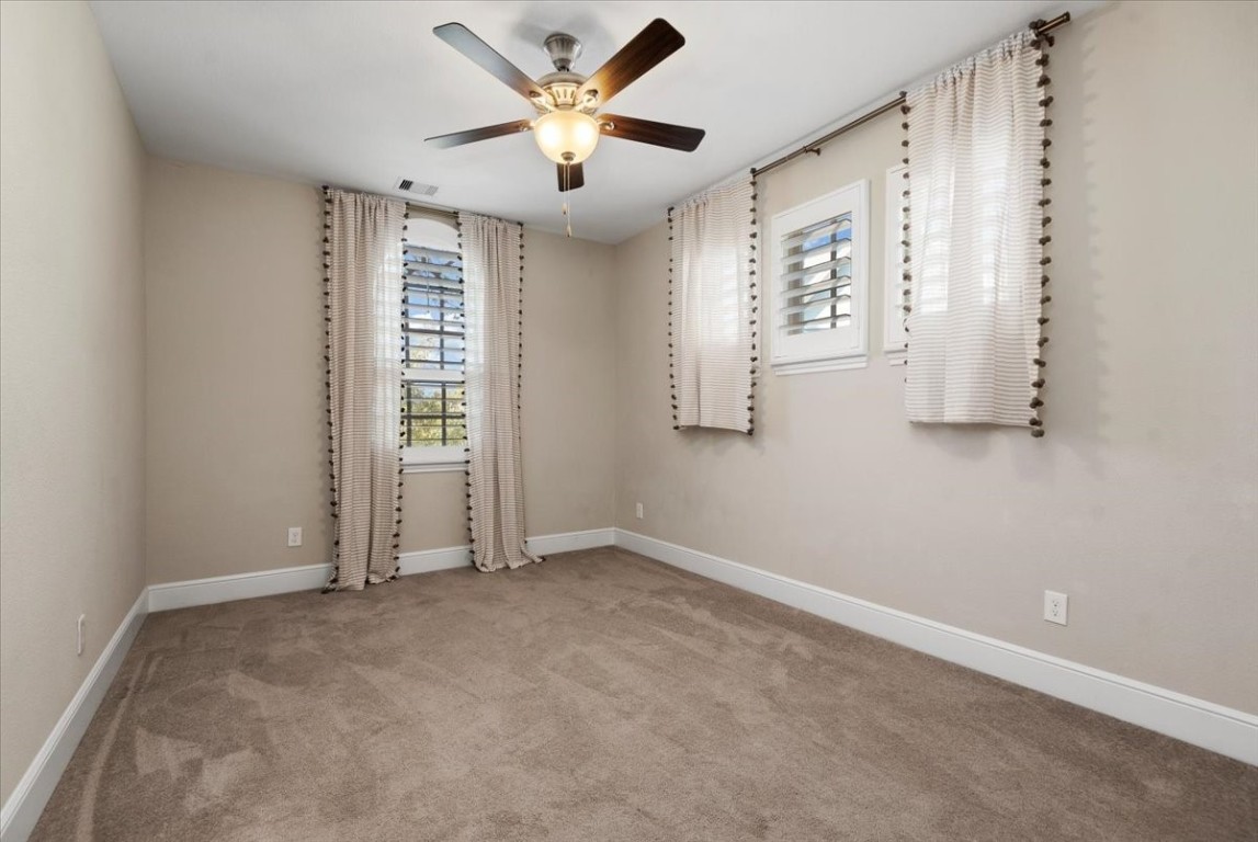 155 Rockwell Park Spring, TX 77389 - Photo 34 of 50 Discover the charm of Bedroom 2 upstairs, featuring cozy carpeted flooring, elegant window treatments, and a ceiling fan for comfort and style.