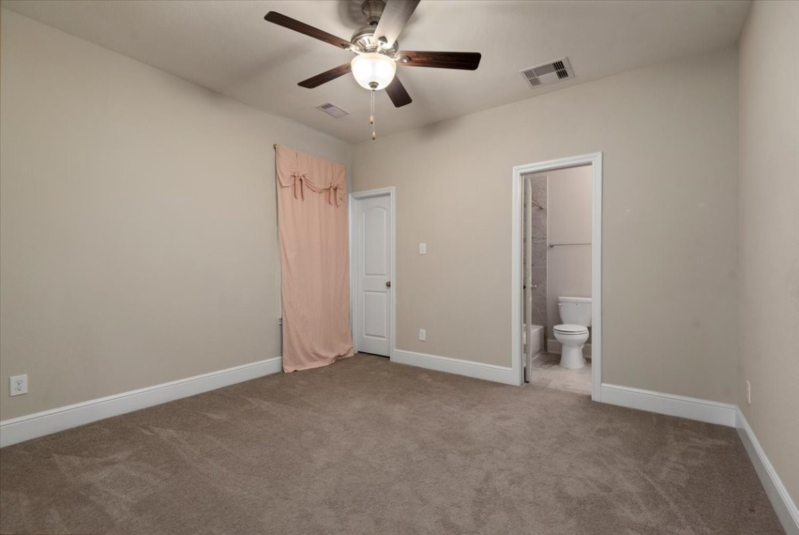 155 Rockwell Park Spring, TX 77389 - Photo 35 of 50 Experience comfort in this inviting upstairs bedroom featuring soft carpeting, neutral tones, a ceiling fan, and an en-suite bathroom for added convenience.