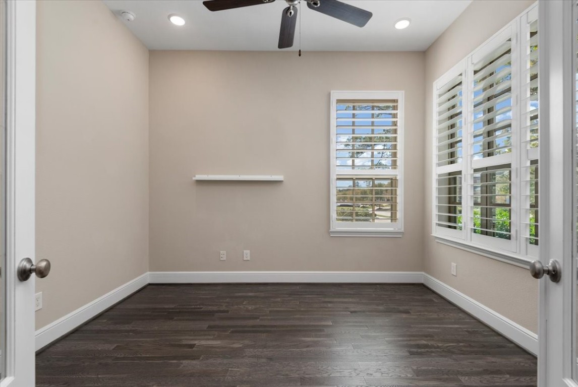 155 Rockwell Park Spring, TX 77389 - Photo 5 of 50 This inviting home office/study boasts ample natural light through large windows, complemented by elegant shutters and a sleek ceiling fan, creating a perfect blend of comfort and productivity.