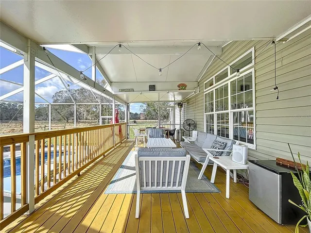 a kitchen with sink refrigerator and couches with wooden floor