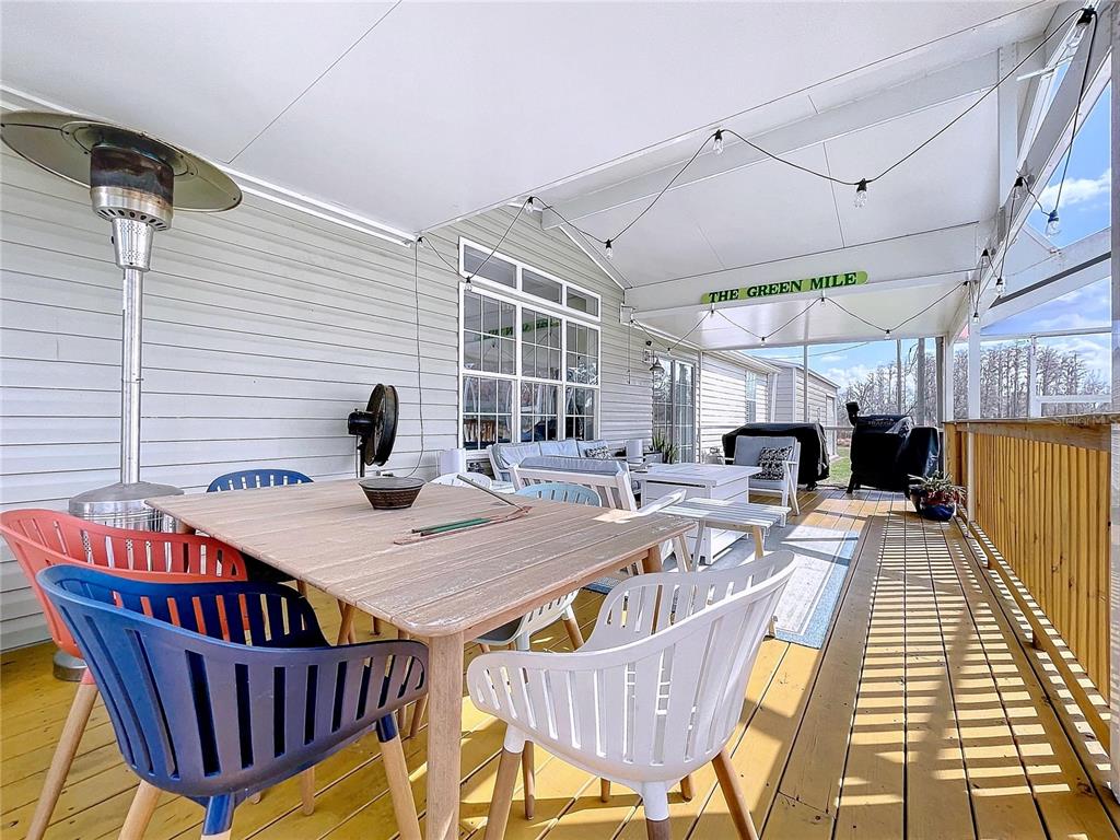14890 County Road 757 Webster, FL 33597 - Photo 97 of 100 a view of a roof deck with table and chairs a barbeque