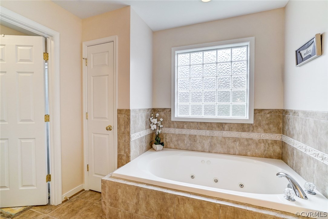 13001 Chipstead Road Chester, VA 23831 - Photo 16 of 31 a white bath tub sitting in a bathroom next to a window