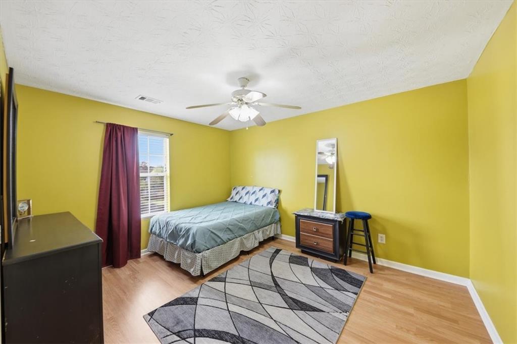 109 Tyler Way Jackson, GA 30233 - Photo 31 of 44 a bedroom with a bed and wooden floor